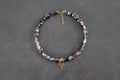 Collier perles polygonales noir et reflets vert, bleu, jaune et violets