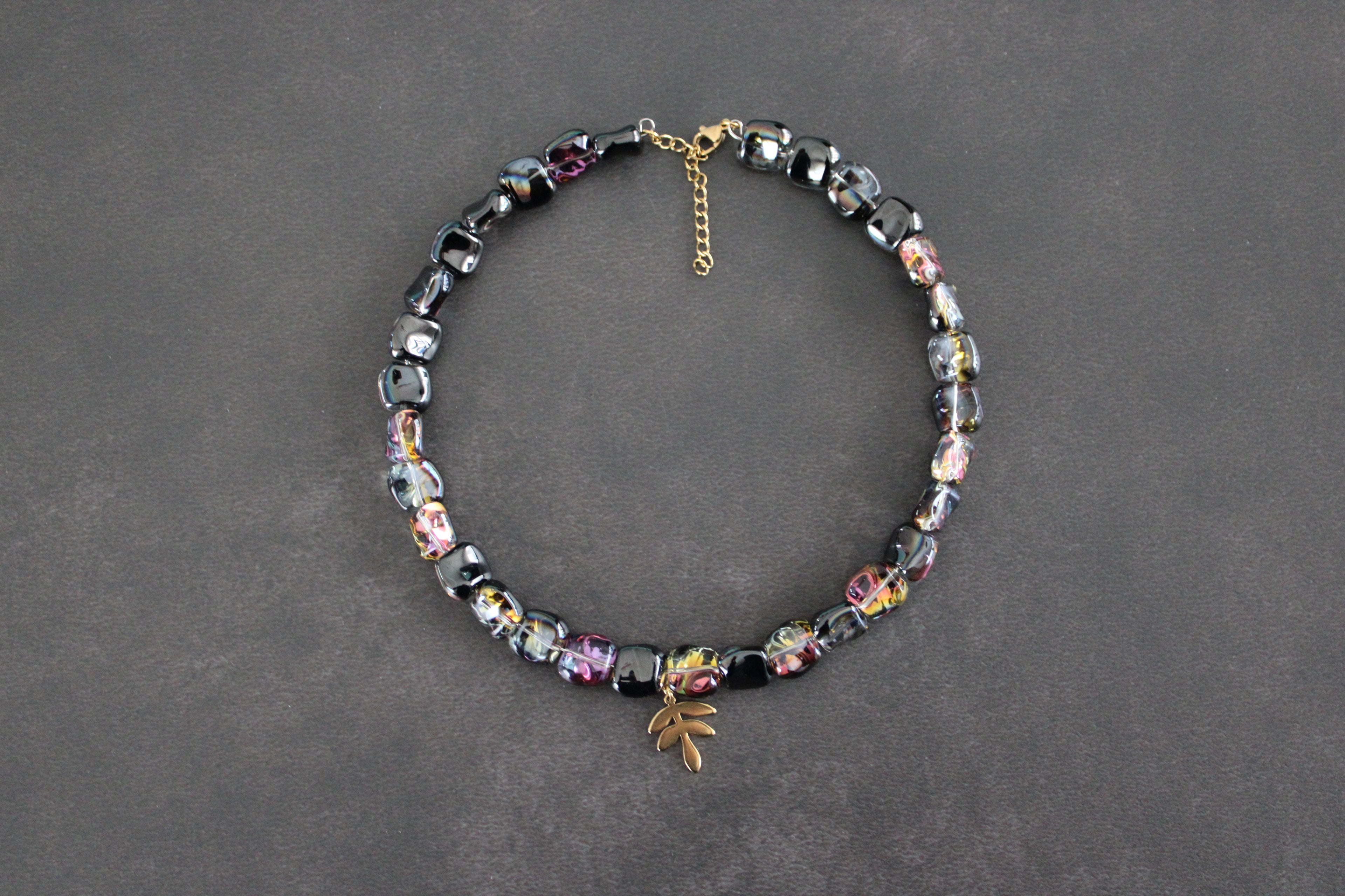 Collier perles polygonales noir et reflets vert, bleu, jaune et violets